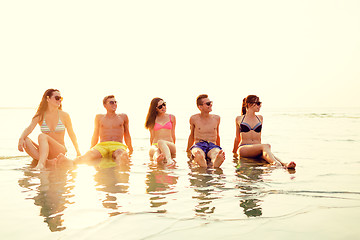 Image showing smiling friends in sunglasses on summer beach