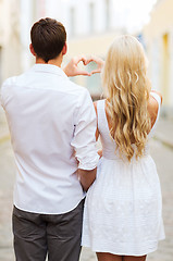 Image showing romantic couple in the city making heart shape
