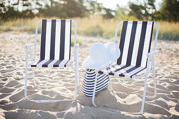 Image showing two beach lounges with beach bag and white hat