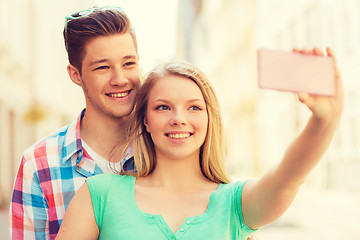 Image showing smiling couple with smartphone in city