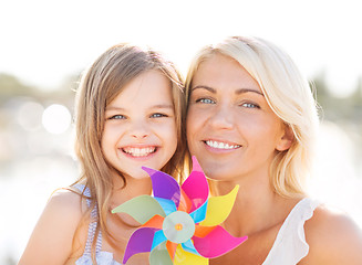 Image showing happy mother and child girl with pinwheel toy