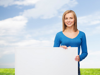 Image showing smiling young woman with blank white board