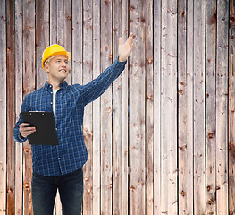 Image showing smiling male builder in helmet with clipboard