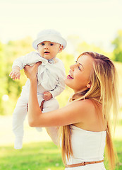 Image showing happy mother with little baby sitting on blanket