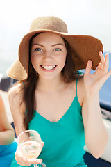 Image showing smiling girl in hat with champagne glass