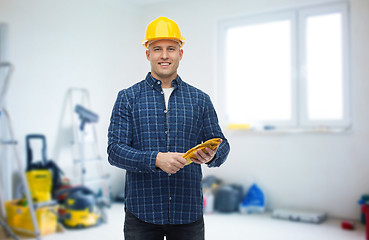 Image showing smiling man in helmet with gloves over room