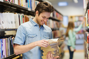 Image showing happy student or man with book in library