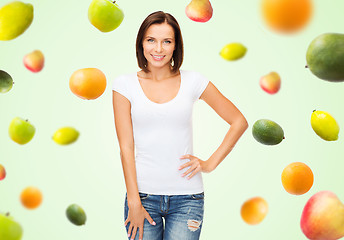 Image showing happy woman in blank white t-shirt over fruits