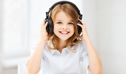 Image showing little girl with headphones at home