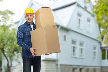 Image showing smiling man in helmet with cardboard boxes