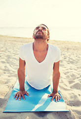 Image showing man doing yoga exercises outdoors