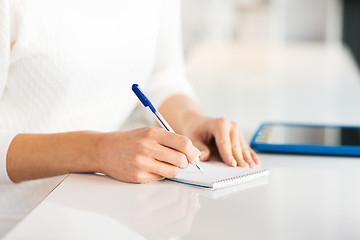 Image showing close up of hands with pen writing to notepad