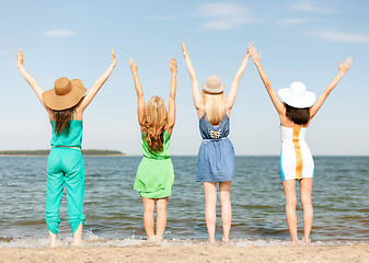 Image showing girls with hands up on the beach