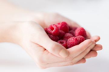 Image showing close up of woman hands holding raspberries