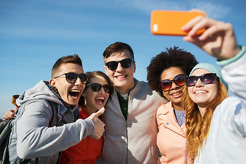 Image showing smiling friends taking selfie with smartphone