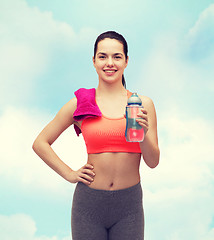 Image showing sporty woman with towel and water bottle