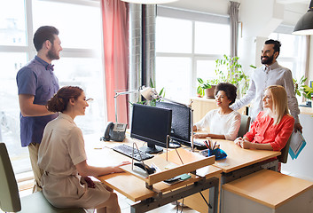 Image showing happy creative team talking in office