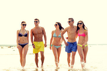 Image showing smiling friends in sunglasses on summer beach