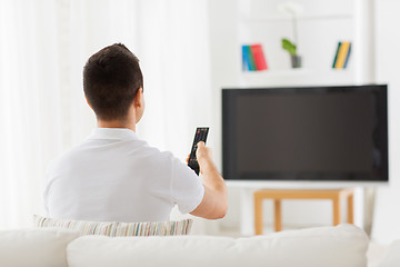 Image showing man watching tv and changing channels at home