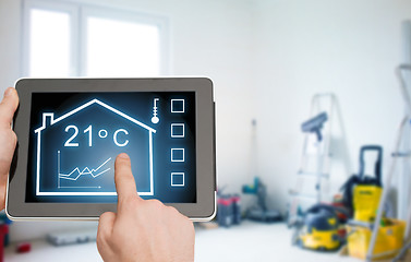 Image showing close up of tablet pc in hands setting temperature