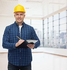 Image showing smiling male builder in helmet with clipboard