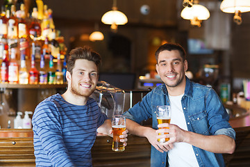 Image showing happy male friends drinking beer at bar or pub