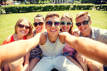 Image showing group of smiling friends making selfie in park