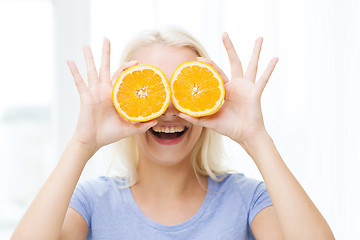 Image showing happy woman having fun covering eyes with orange