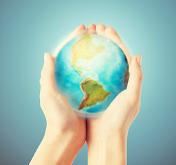 Image showing close up of human hands with earth globe