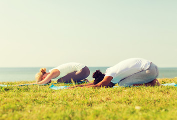 Image showing couple making yoga exercises outdoors