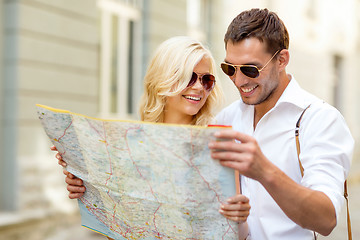 Image showing smiling couple in sunglasses with map in the city