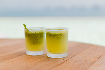 Image showing glasses of fresh juice or cocktail on beach