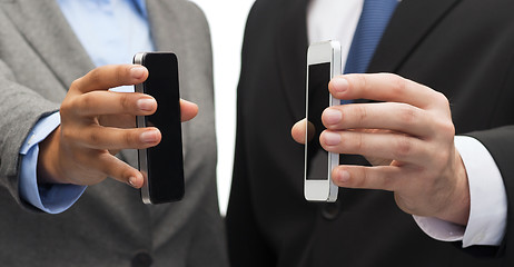 Image showing businessman and businesswoman with smartphones