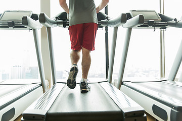 Image showing close up of male legs running on treadmill in gym