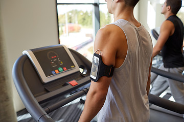 Image showing smiling men exercising on treadmill in gym