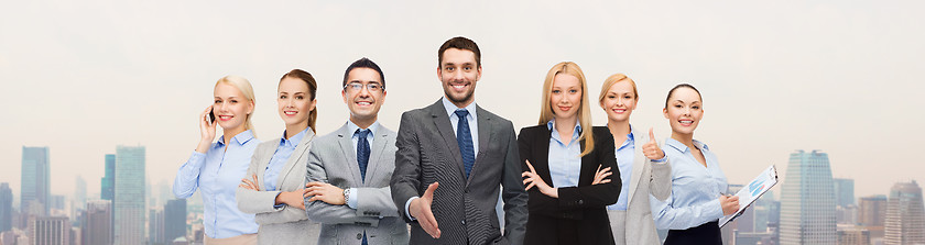 Image showing group of smiling businessmen making handshake