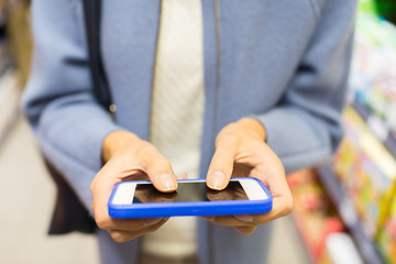 Image showing close up of woman with smartphone in market