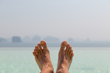 Image showing closeup of male feet over sea and sky on beach