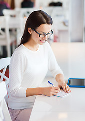 Image showing smiling woman with tablet pc at cafe