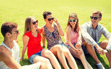 Image showing group of smiling friends outdoors sitting in park