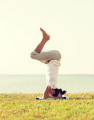 Image showing man making yoga exercises outdoors