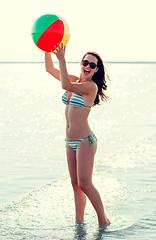 Image showing smiling teenage girl sunglasses with ball on beach