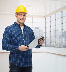 Image showing smiling male builder in helmet with clipboard