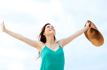 Image showing girl with hands up on the beach