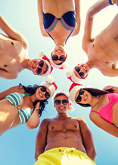 Image showing smiling friends in circle on summer beach