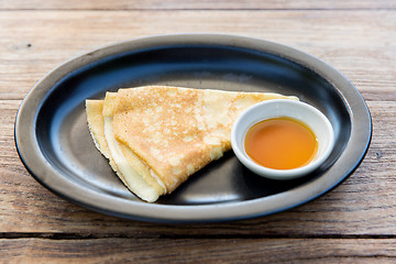 Image showing close up of pancakes and honey or jam on plate