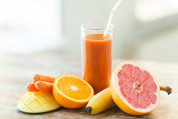 Image showing close up of fresh juice glass and fruits on table