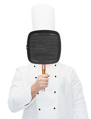 Image showing male chef cook covering face with grill pan