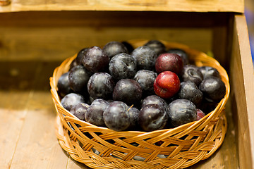 Image showing ripe plums in basket at farm or food market