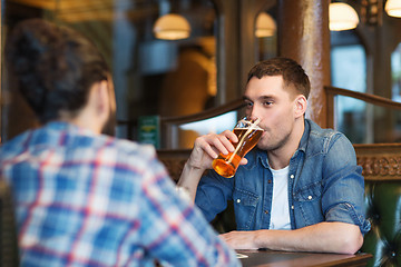 Image showing happy male friends drinking beer at bar or pub